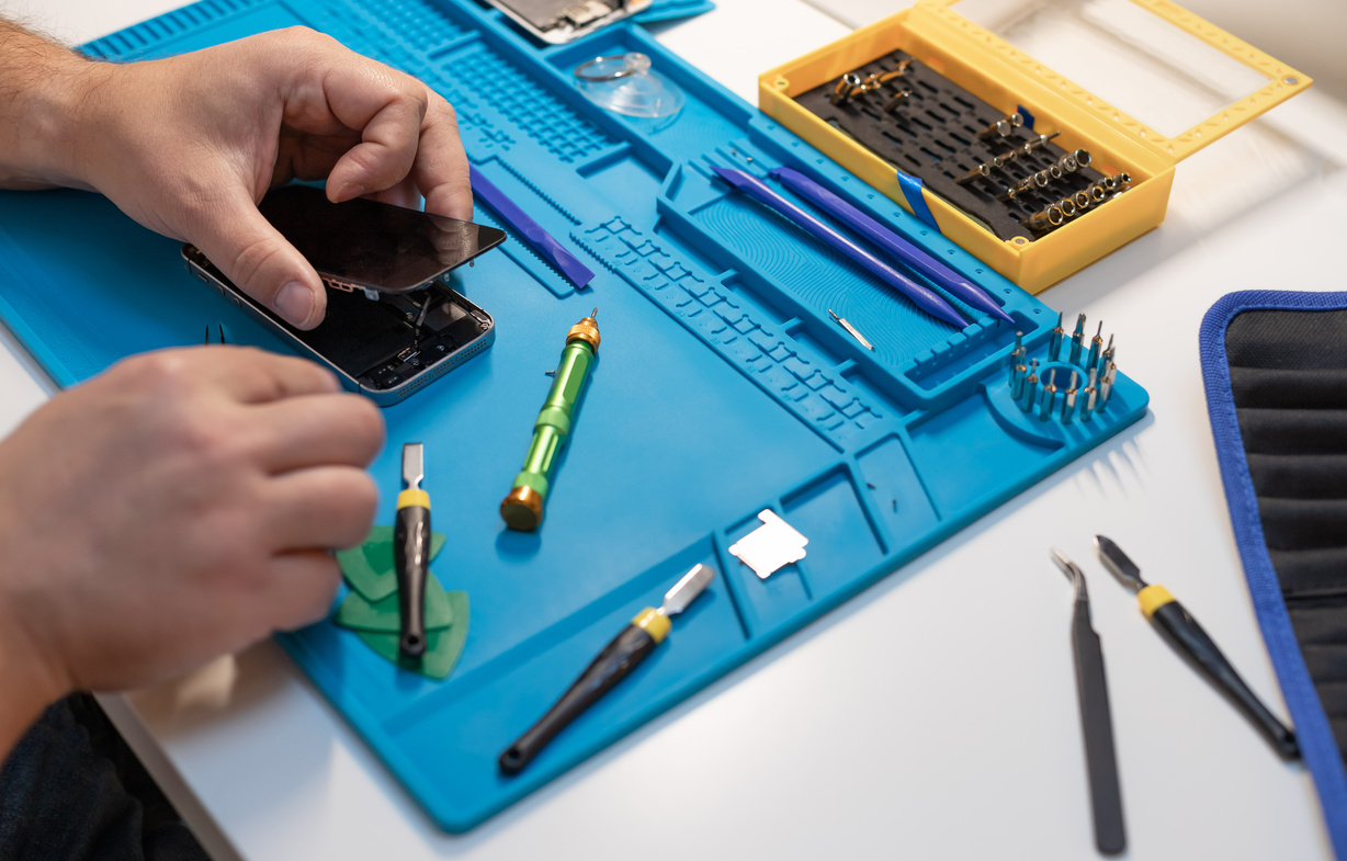 Technician fixing broken smartphone. Electronics repair service